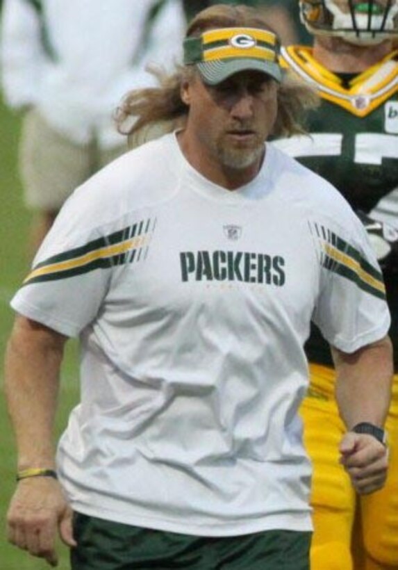 A man looks at football players.