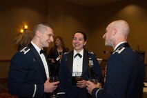 Military members talk during annual NDIA ball where one was honored.