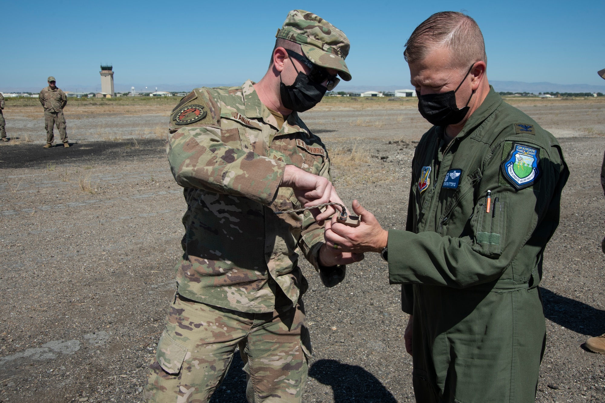 An Airman shows the colonel how to operate a detonator.