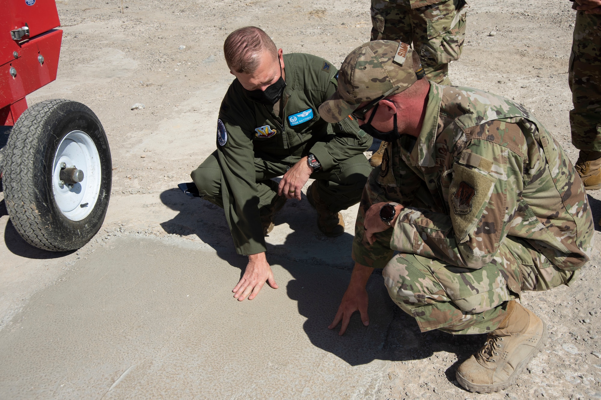 An Airman shows how effective rapidset concrete is for ground damage recovery to the Colonel.