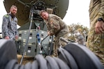 Men work on satellite communications.