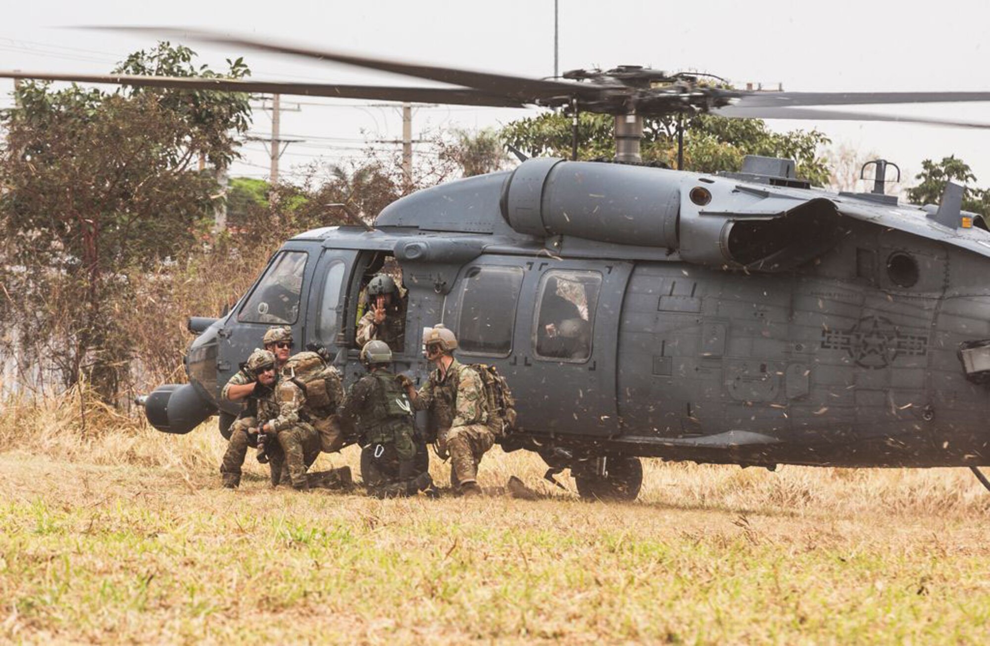 Brazilian airmen and pararescue Airmen from the New York Air National Guard's 106th Rescue Wing exit an HH-60 Pave Hawk  while participating in Exercise Tapio 2021 at Campo Grande Air Base, Campo Grande, Brazil. The exercise Aug. 19-31 was part of the National Guard's State Partnership Program.
