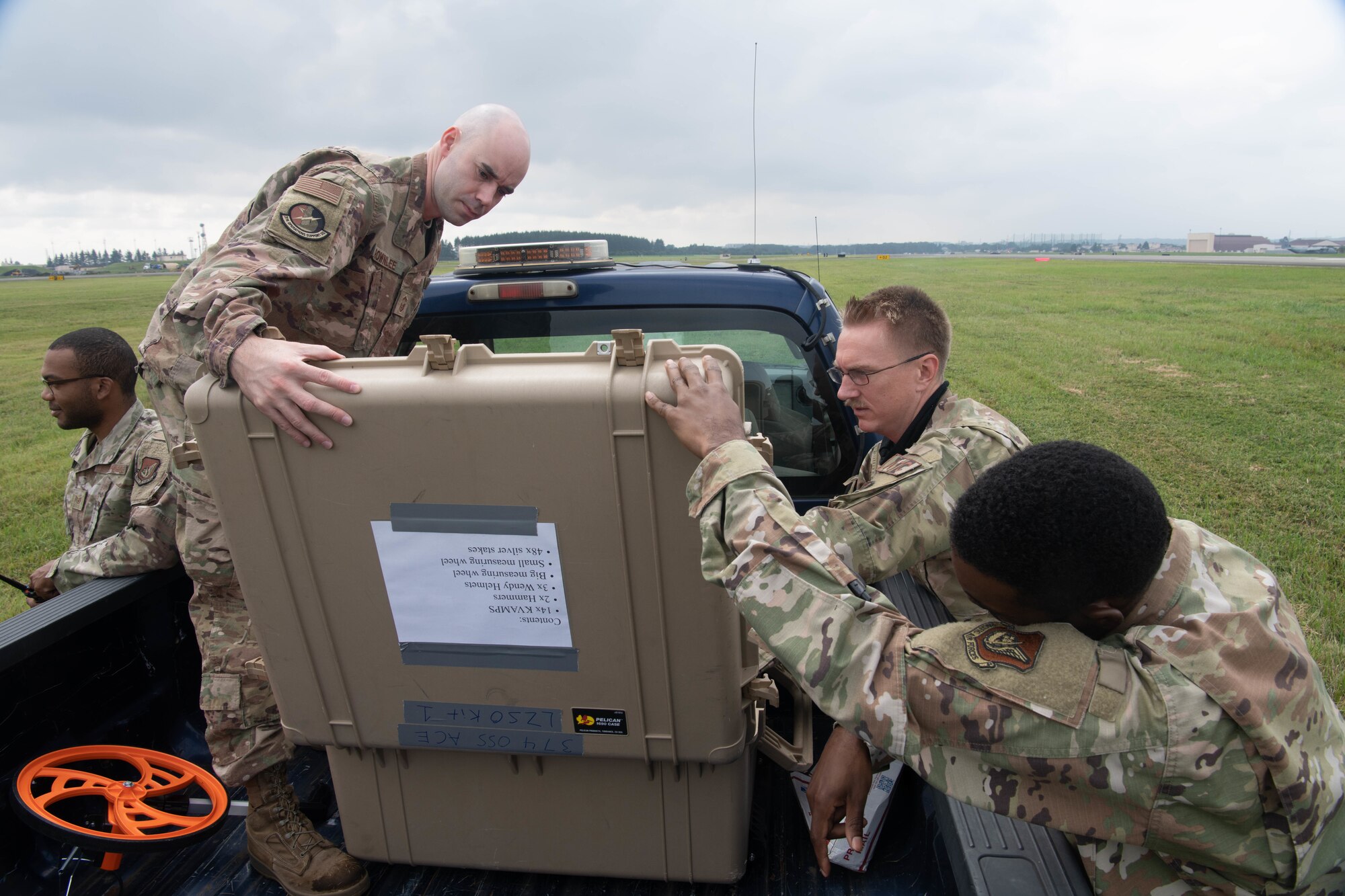 Airmen looking into a supply box