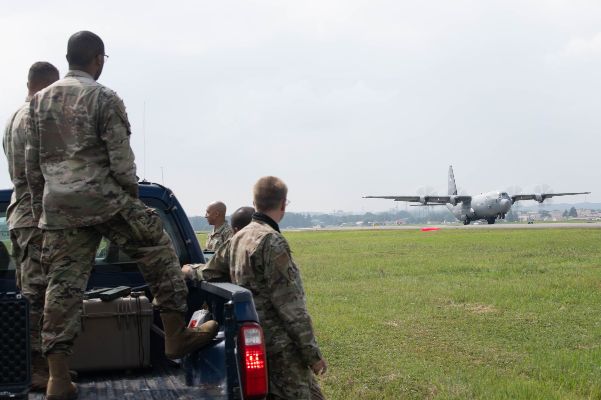 Airmen watch a C-130J Super Hercules landing on Yokota's flightline