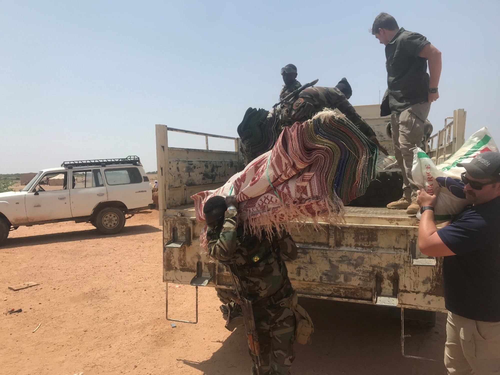 Members of the U.S. civil affairs and Forces Armees Nigeriennes Action Civil‐Militaire teams unload humanitarian supplies in Teghazert, Niger on Sept 8, 2021.  U.S. civil affairs teams have accomplished more than 1,000 civil engagements with local schools, women’s groups, and civilian leadership in Niger, helping to improve public understanding and appreciation of joint security operations. (Courtesy photo)