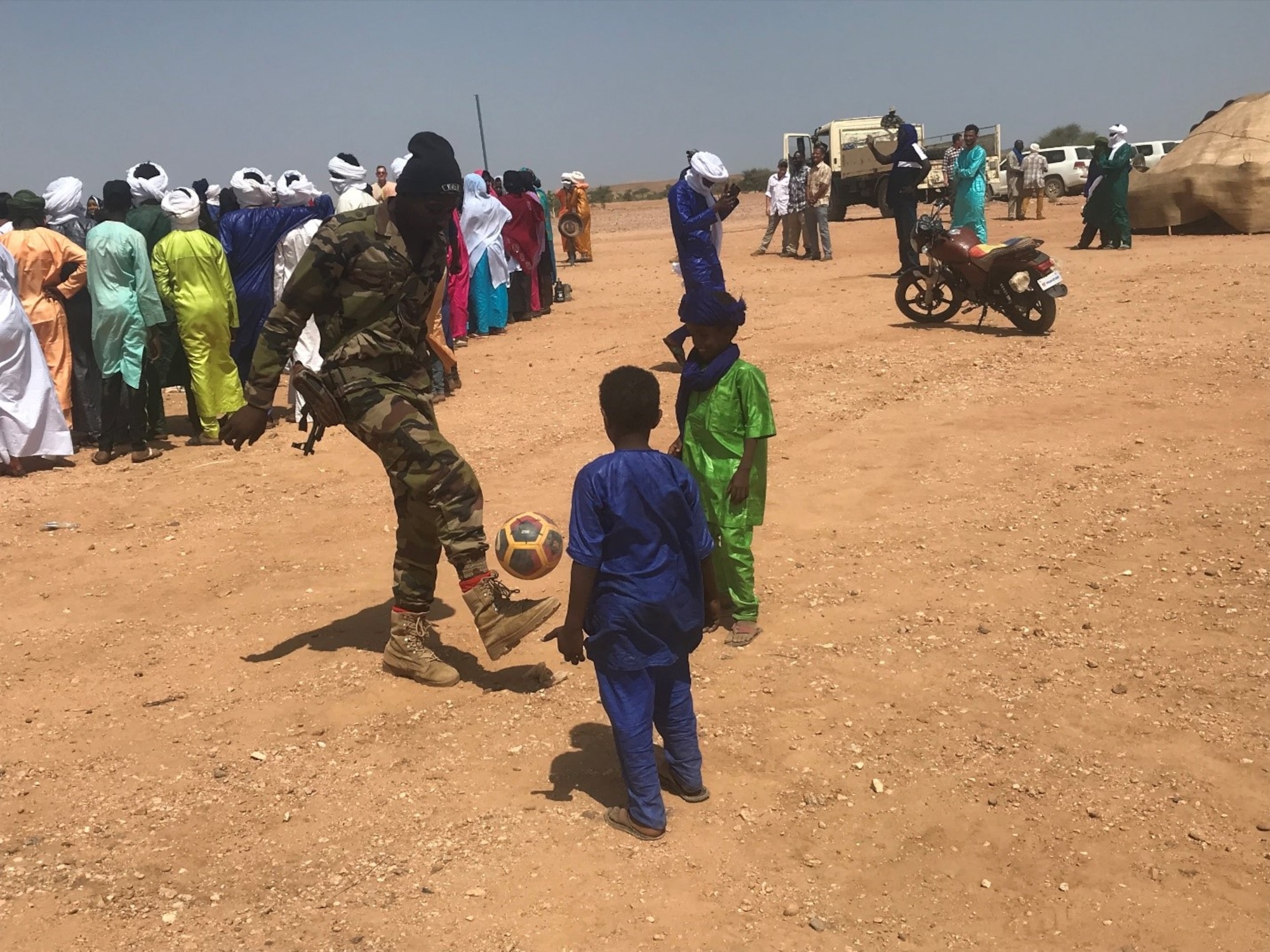 A member of the Forces Armees Nigeriennes Action Civil‐Militaire plays football with children in Teghazert, Niger on Sept 8, 2021.  Footballs, due to their popularity with the youth, are regularly donated along with other items. (Courtesy photo)
