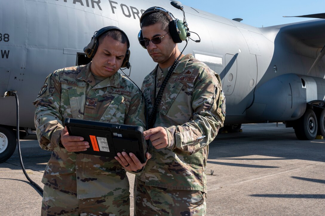Two Airmen look at a tablet