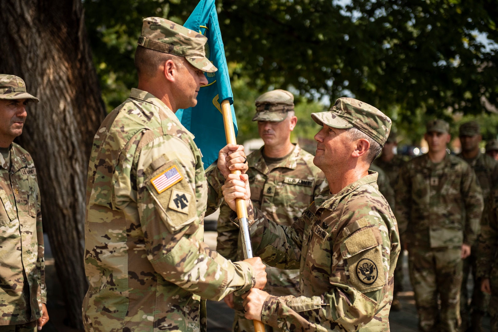 Oklahoma National Guard Lt. Col. Carl Bennett,  outgoing commander with the 63rd CST, passes the unit guidon to Col. Lars Ostervold, commander of the 90th Troop Command, during a change of command ceremony at the Oklahoma City Memorial and Museum, Sept. 1.  The passing of the guidon signifies the formal transfer of authority and responsibility of the unit to the new commander.