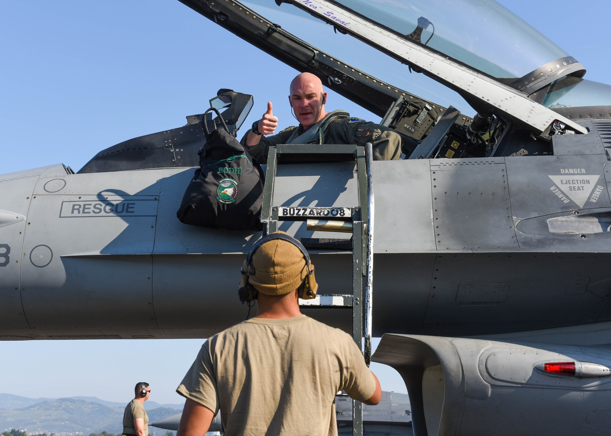 U.S. Air Force Capt. Michael Kelvin, 555th Fighter Squadron F-16 Fighting Falcon pilot, hands a gear bag to a U.S. Air Force F-16 crew chief assigned to the 555th Aircraft Maintenance Unit during Agile Wyvern at Cerklje ob Krki Air Base, Slovenia, Sept. 8, 2021. U.S. Air Force F-16s and Airmen assigned to the 31st Fighter Wing participated in Agile Wyvern alongside the Slovenian Armed Forces, September 7-10. (U.S. Air Force photo by Senior Airman Brooke Moeder)