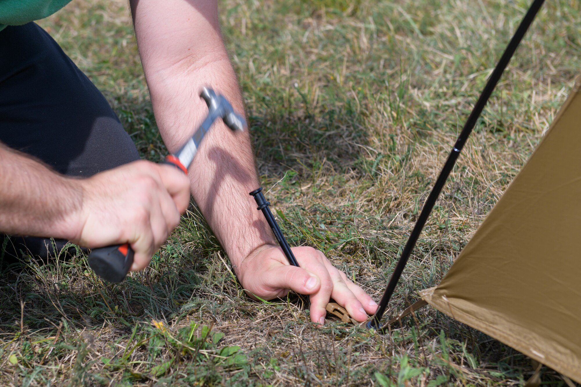 A U.S. Air Force Airman assigned to Aviano Air Base, Italy, hammers a tent stake into the ground during exercise Agile Wyvern at Cerklje ob Krki Air Base, Slovenia, Sept. 7, 2021. Agile Wyvern supported the Agile Combat Employment concept by temporarily bedding down personnel and equipment at a dispersed location to support the overall mission. (U.S. Air Force photo by Senior Airman Brooke Moeder)