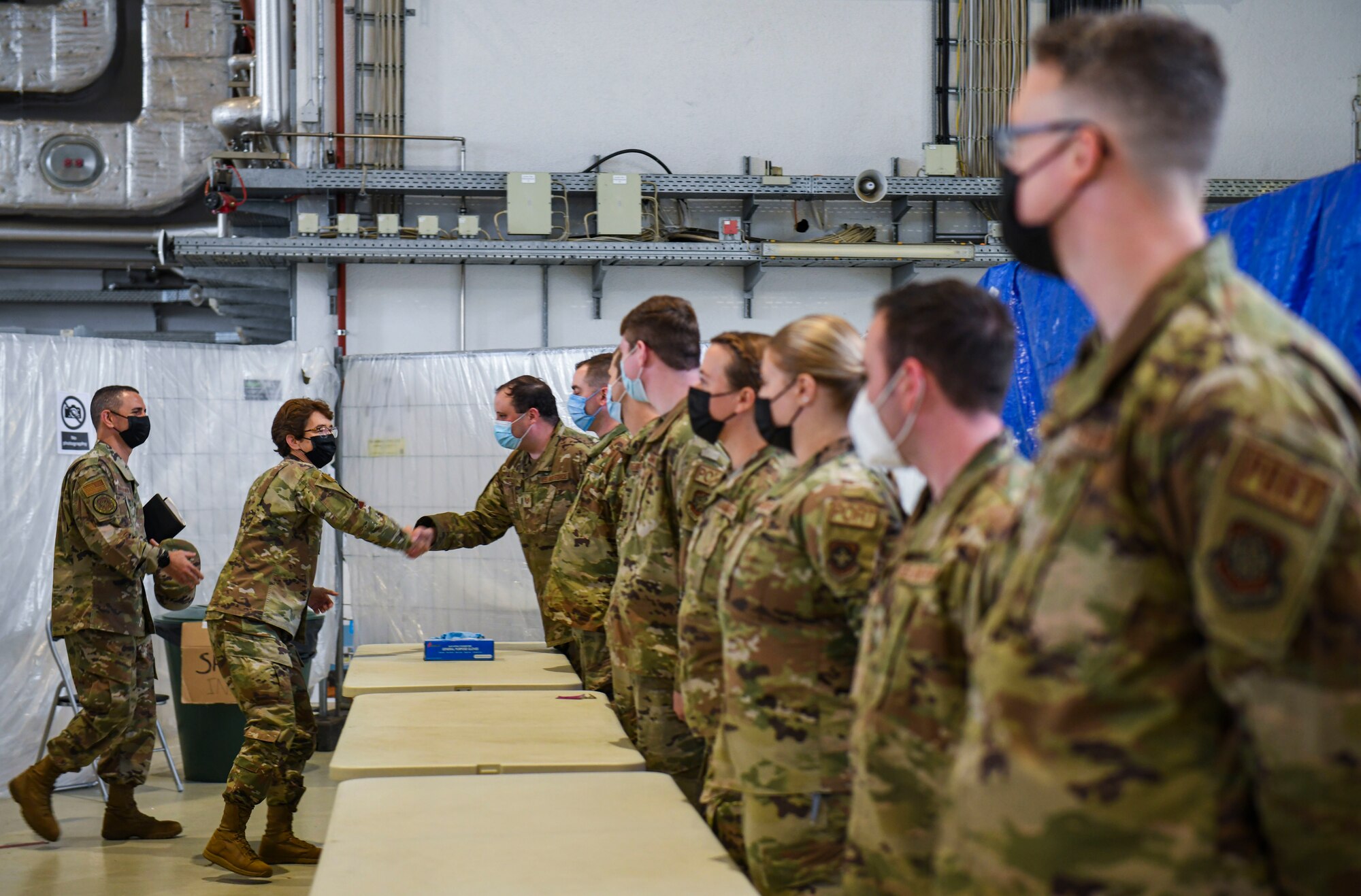 General shakes hands with Airmen.