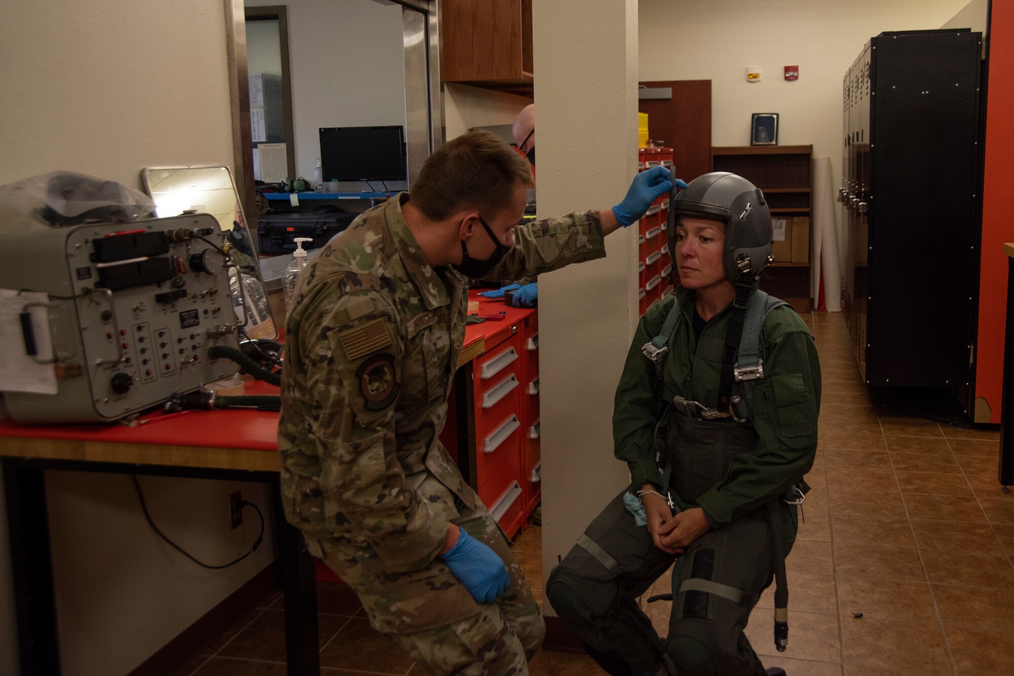 An Airman uses a six inch ruler to measure the distance between the visor buffer at the front edge of the helmet and the Boise Mayor's eyes