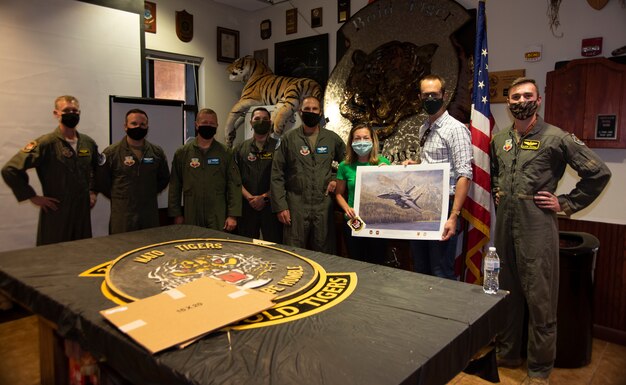 The Boise Mayor and her husband holds a poster and pose for a photo with fellow Airmen.