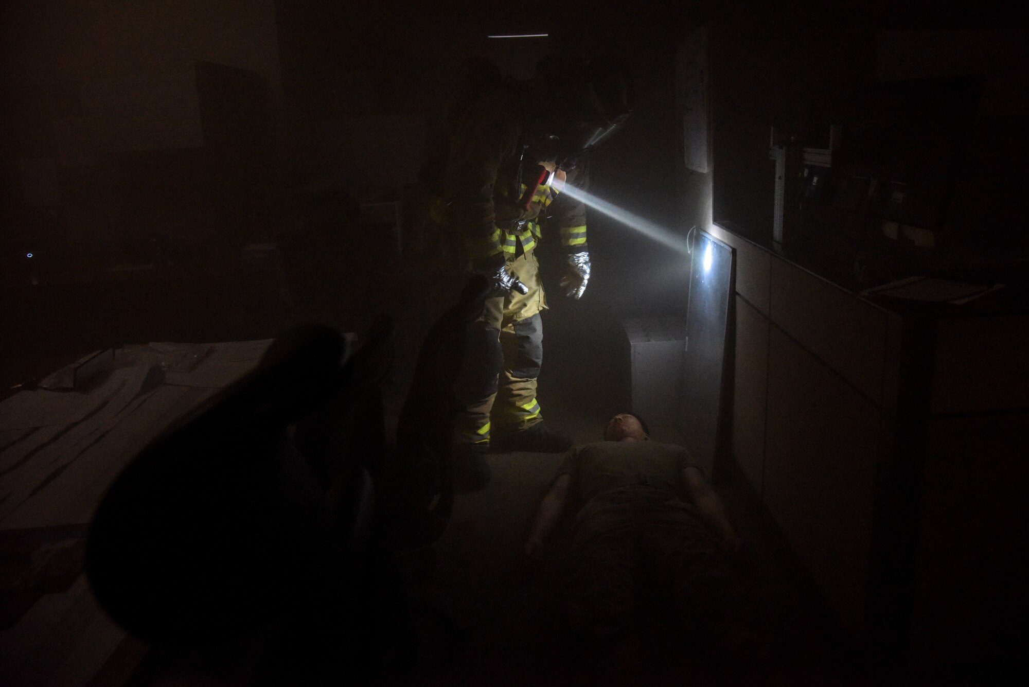A firefighter from the 51st Civil Engineer Squadron discovers a wounded Airman during a training scenario