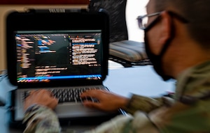 Photo of a man typing on a laptop.