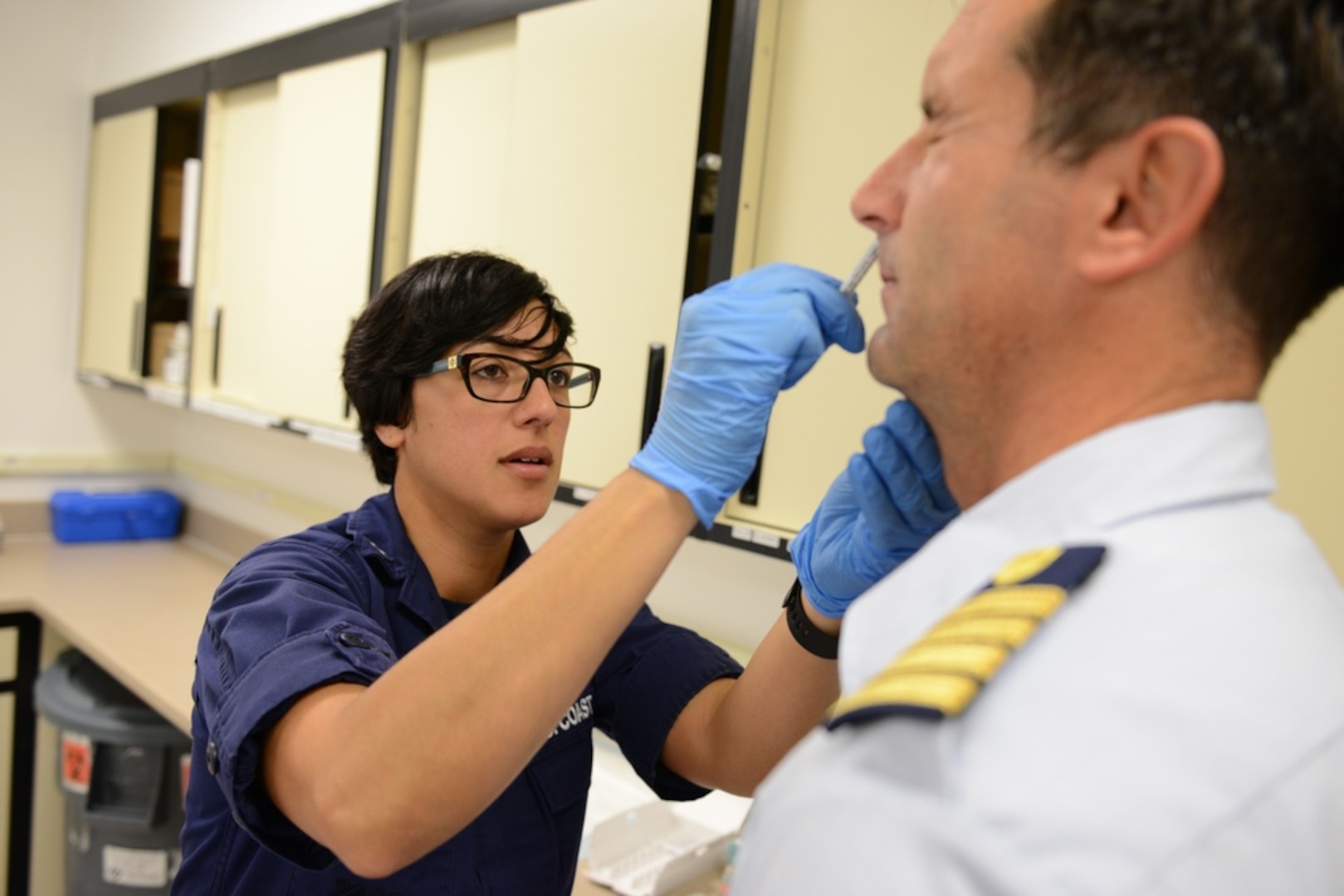 Petty Officer 3rd Class Amber Degouveia, a health series technician assigned to Coast Guard Base Alameda Medical, administers the intranasal flu vaccine to a Coast Guard member while at the Base Alameda clinic Thursday, Oct. 1, 2015. To maintain mission readiness, Coast Guard personnel are required to receive the annual influenza vaccine during the required vaccination period. (U.S. Coast Guard photo by Petty Officer 2nd Class Barry Bena)