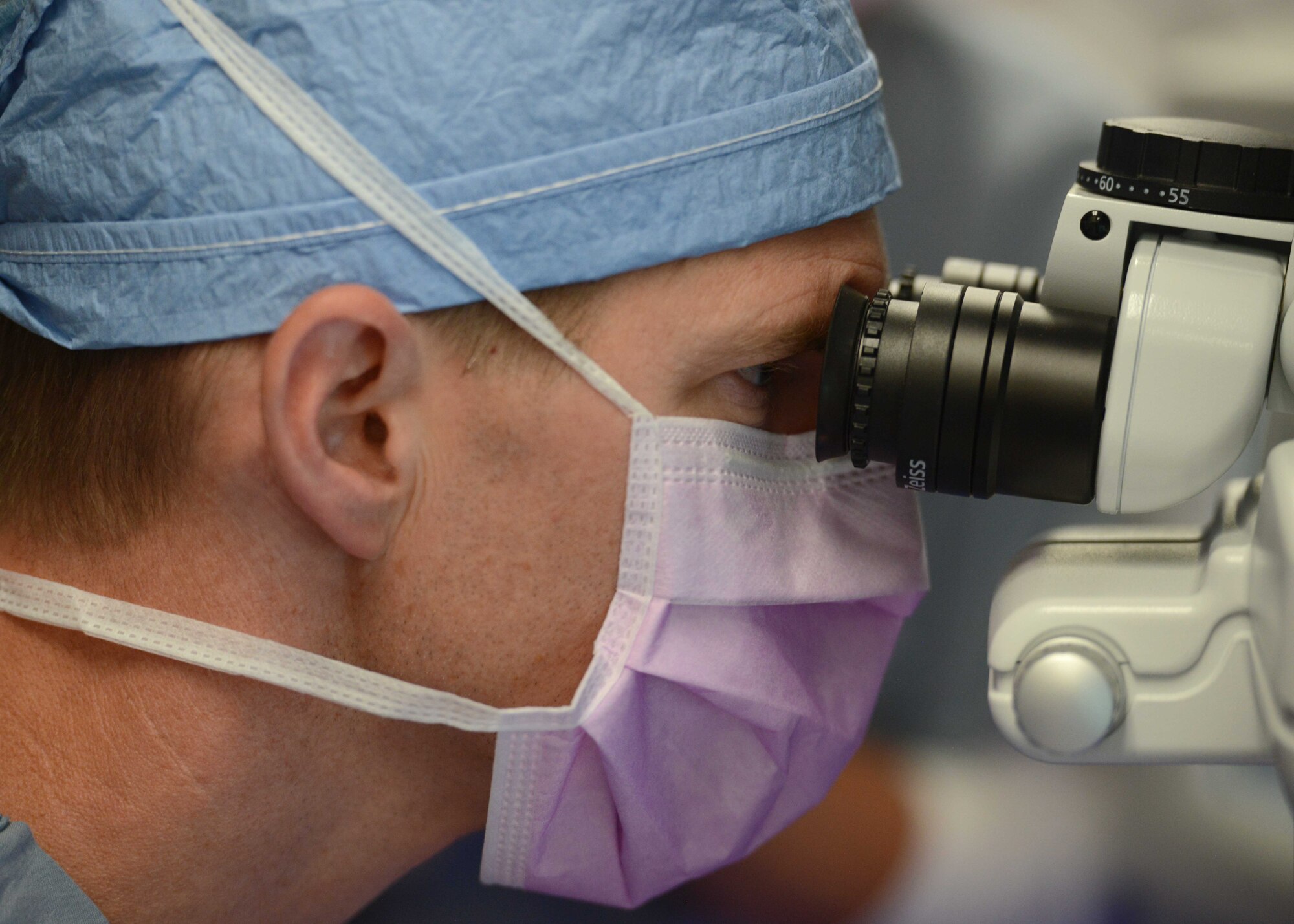 Lt. Col. Marcus Neuffer, chief surgeon assigned to the 10th Medical Group, Air Force Academy, Colo., looks through a microscope during a small incisional lenticular extraction (SMILE) eye surgery, Aug. 19, 2021.