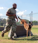 U.S. Air Force Senior Airman Taylor Bryant, 902nd Security Forces Squadron military working dog handler, runs with his MWD during a hurdle training exercise