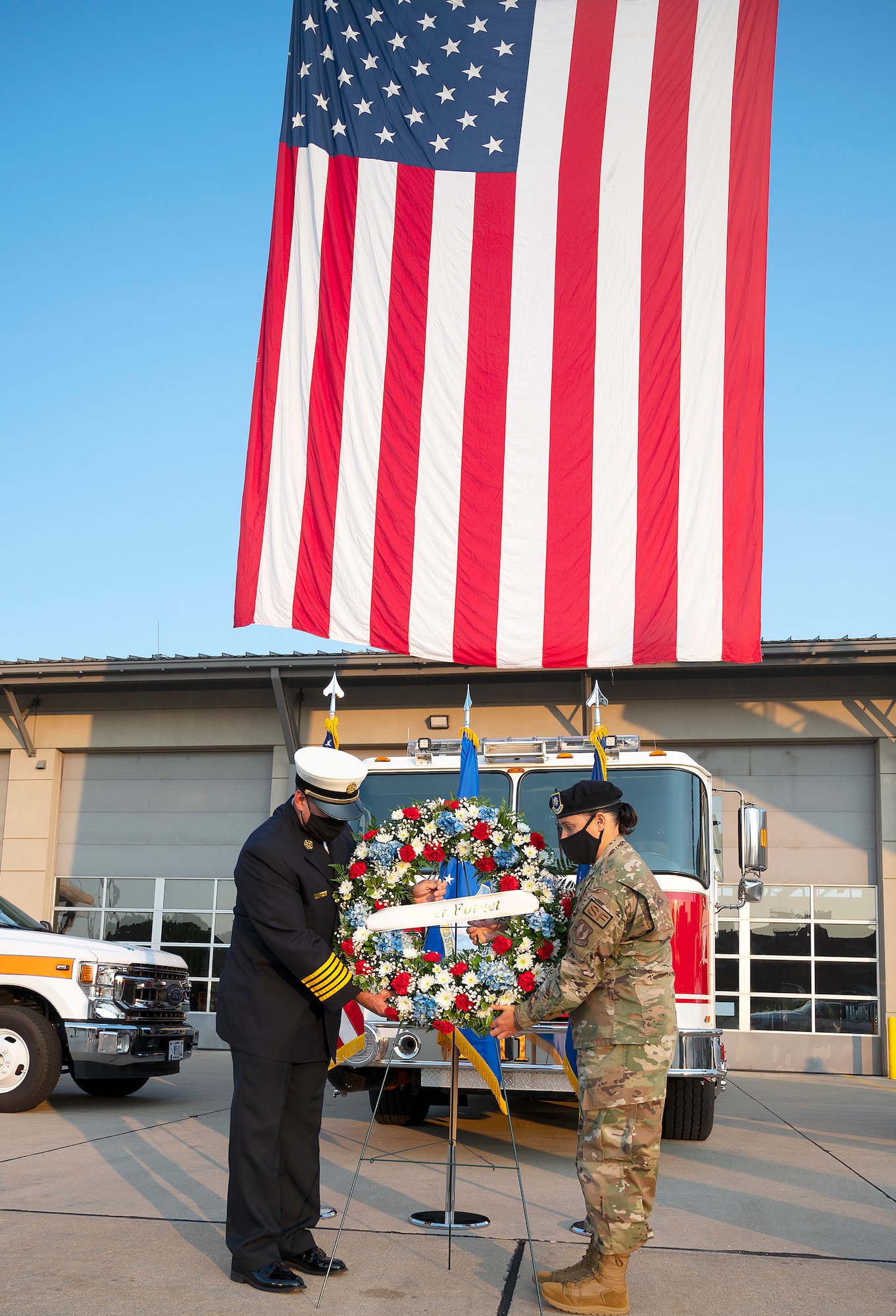 Jacob King, 788th Civil Engineer Squadron fire chief, and Lt. Col. Nicole Schatz, 88th Security Forces Squadron commander, place a wreath in front of Fire Station One during commemoration of the 20th anniversary of the 9/11 attacks Sept. 10, 2021, at Wright-Patterson Air Force Base, Ohio. King and Schatz symbolized the firefighters and police officers who died in the attack. (U.S. Air Force photo by R.J. Oriez)