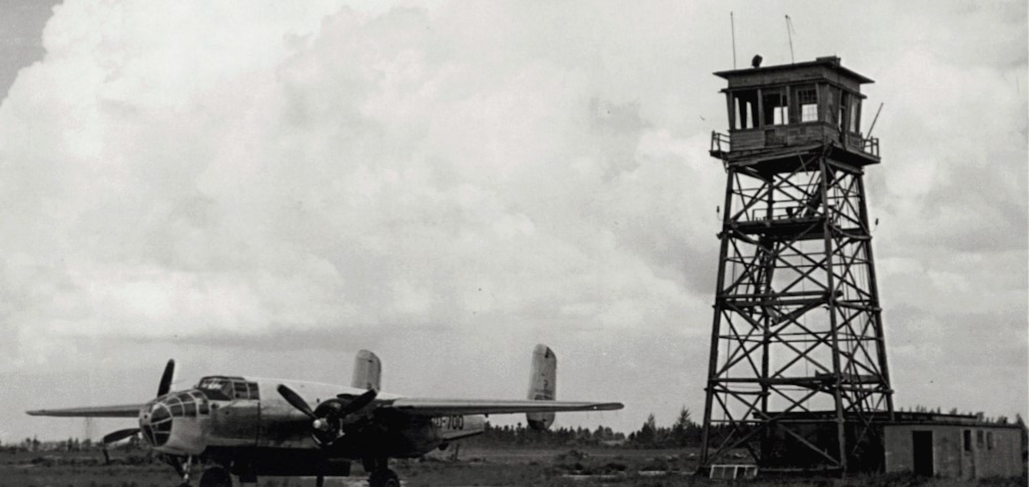 A B-25 Transient sits next to the tower at Homestead Air Force Base.