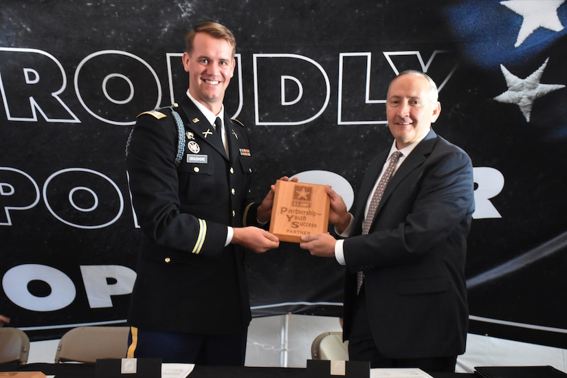 two men pose for a photo, both holding a plaque.