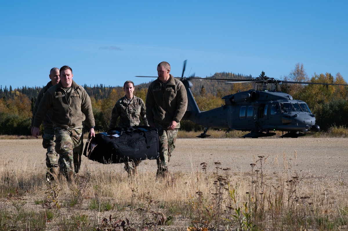 U.S. Airmen assigned to the 673rd Medical Group carry a go-bag of medical supplies and equipment during a Capabilities-Based Assessment (CBA) at the Yukon Training Area, Sept. 14, 2021.