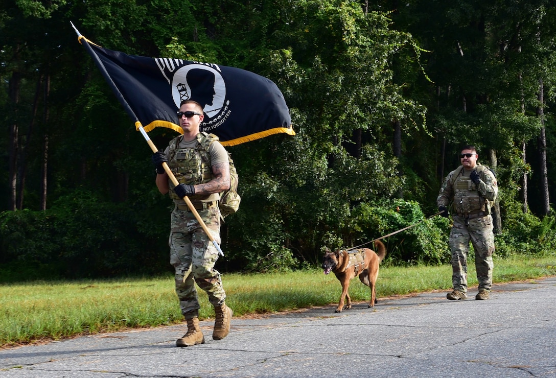 Tech. Sgt. Kyle Shy, left, 4th Security Forces Squadron military working dog kennel master, MWD Eenoch, and Staff Sgt. Jesus Amaya, 4th SFS MWD handler, walk in a unit ruck march at Seymour Johnson Air Force Base.