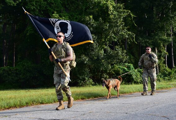 Tech. Sgt. Kyle Shy, left, 4th Security Forces Squadron military working dog kennel master, MWD Eenoch, and Staff Sgt. Jesus Amaya, 4th SFS MWD handler, walk in a unit ruck march at Seymour Johnson Air Force Base.