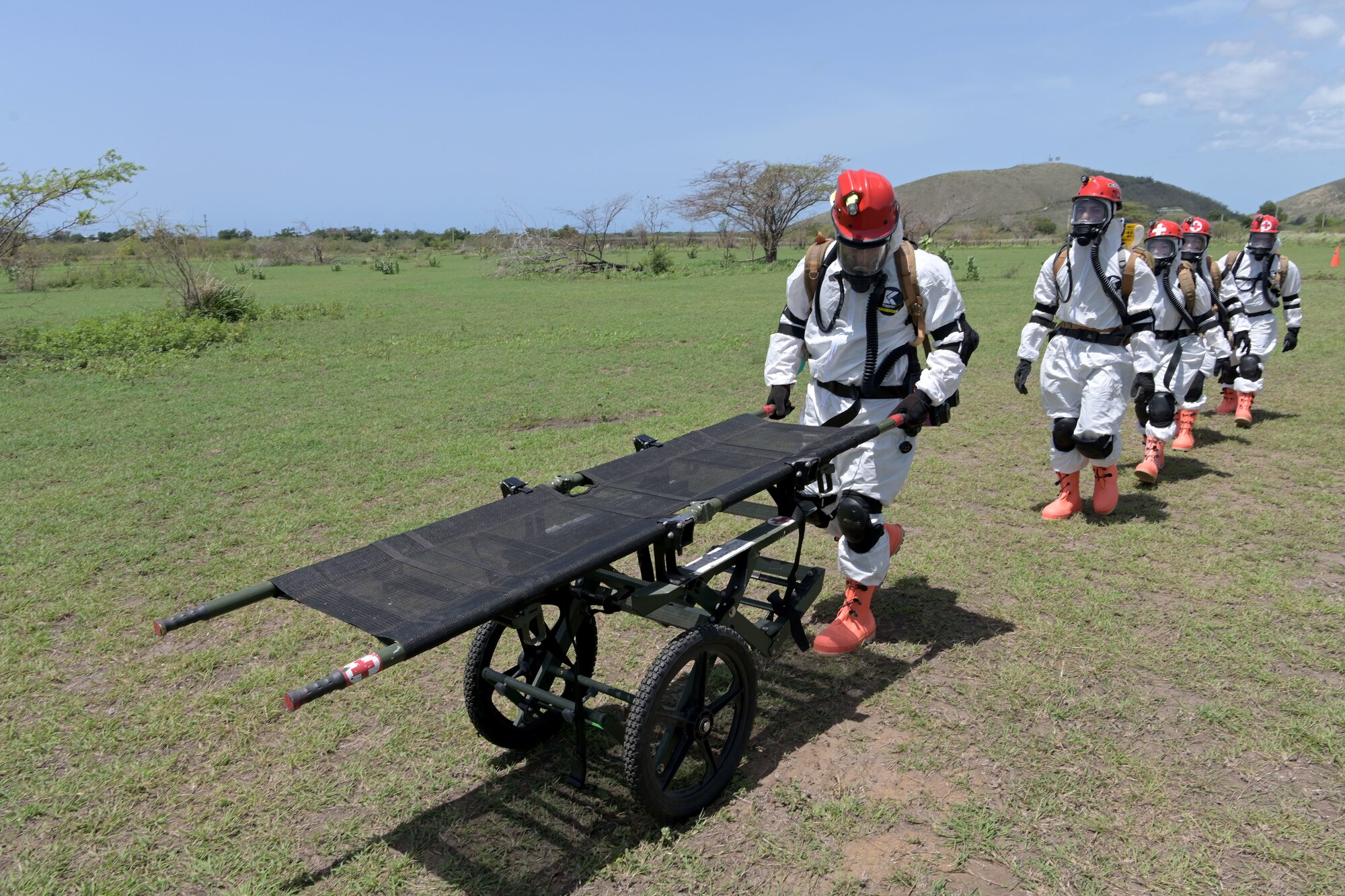 U.S. Airmen with the 156th Medical Group Detachment 1, Chemical, Biological, Radiological, Nuclear and high-yield Explosive Enhanced Response Force Package, walk to the simulated accident site to conduct a search and extraction training exercise at Camp Santiago Joint Training Center, Salinas, Puerto Rico, Aug. 19, 2021