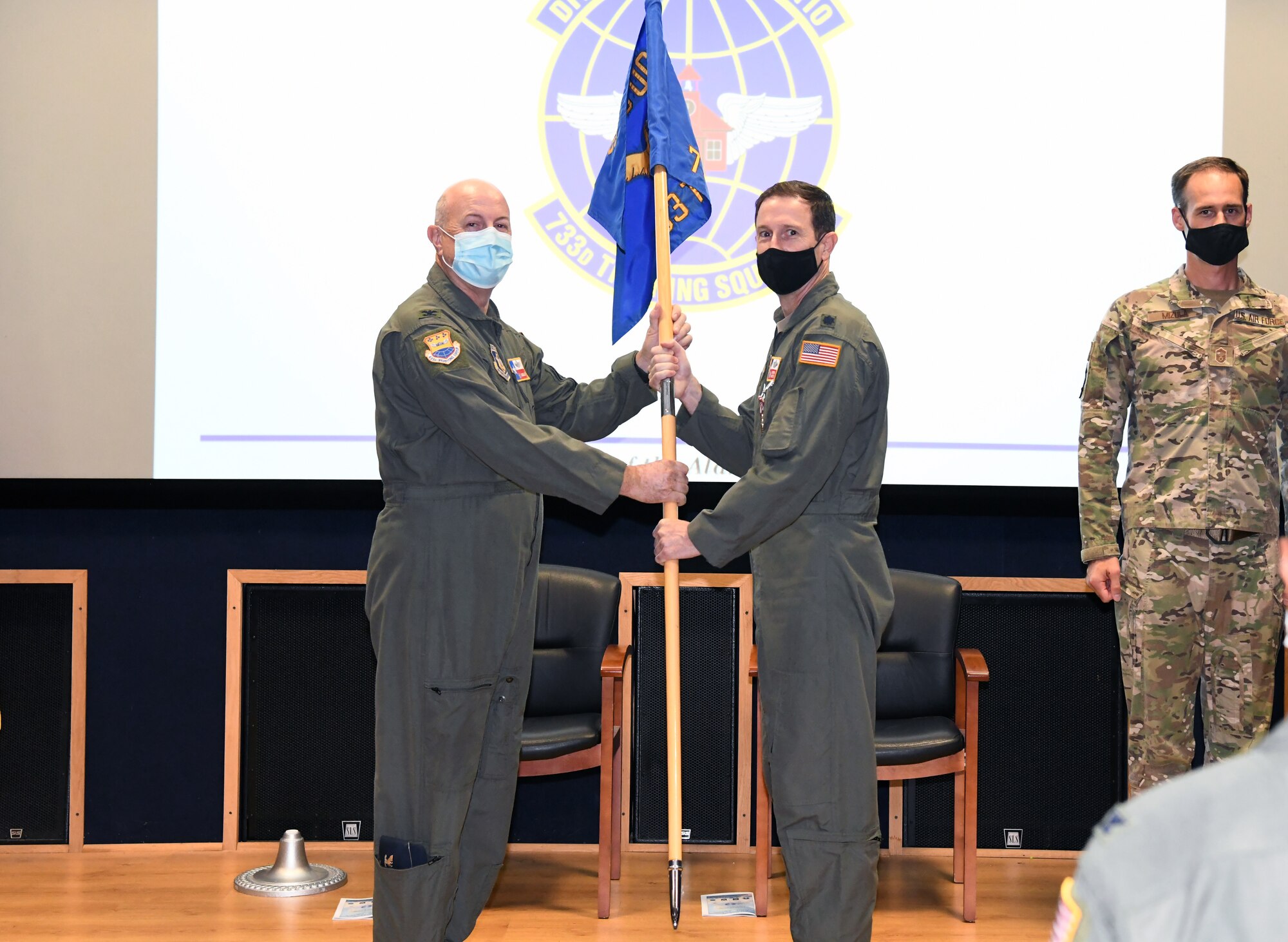 Col. James "JC" Miller, 433rd Operations Group commander, passes the 733rd Training Squadron's guidon to Lt. Col. Steven Radtke signifying his accepting command of the unit Sept. 10, 2021 at Joint Base San Antonio-Lackland, Texas. Previous to this assignment, Radtke was the 356th Training Squadron commander here. (U.S. Air Force photo by Master Sgt. Kristian Carter)