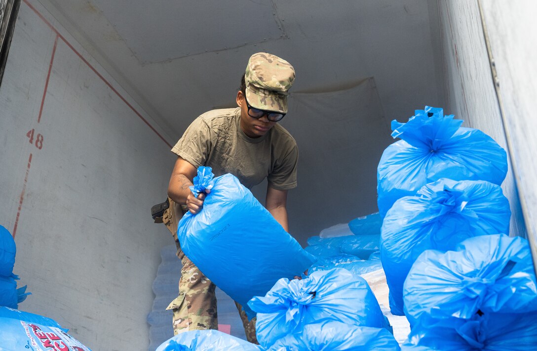 Spc. Telisha Frazier of the 214 MP Company, Alabama stacks ice to hand out to the people of Chauvin, La.