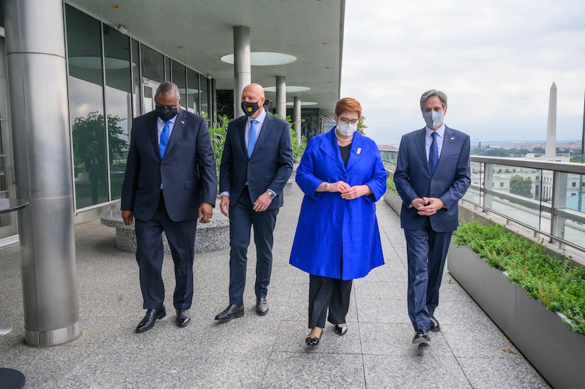 Four officials walk side by side.