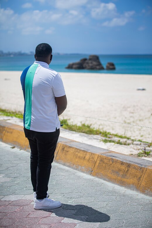 U.S. Marine Corps Lance Cpl. Rhys Stewart, an administrative specialist with the Installation Personnel Administration Center, observes the ocean at Araha Beach, Okinawa, Japan, Sept. 10, 2021. Stewart lived in St. Catherine, Jamaica, with his parents for the first 17 years of his life. In 2017, his grandfather, who was already living in the U.S., filed for Stewart and his family to immigrate to Brooklyn, New York. (U.S. Marine Corps photo by Lance Cpl. Alex Fairchild)