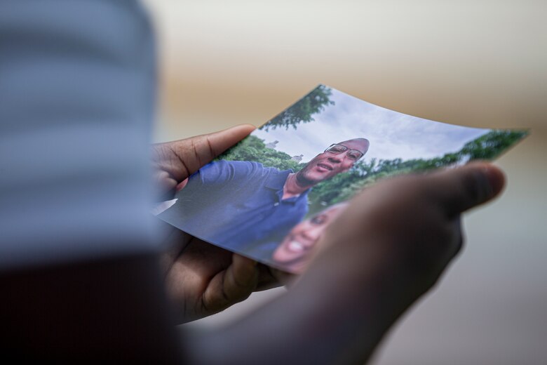 U.S. Marine Corps Lance Cpl. Rhys Stewart, an administrative specialist with the Installation Personnel Administration Center, observes his family photo at Araha Beach, Okinawa, Japan, Sept. 10, 2021. Stewart lived in St. Catherine, Jamaica, with his parents for the first 17 years of his life. In 2017, his grandfather, who was already living in the U.S., filed for Stewart and his family to immigrate to Brooklyn, New York. (U.S. Marine Corps photo by Lance Cpl. Alex Fairchild)