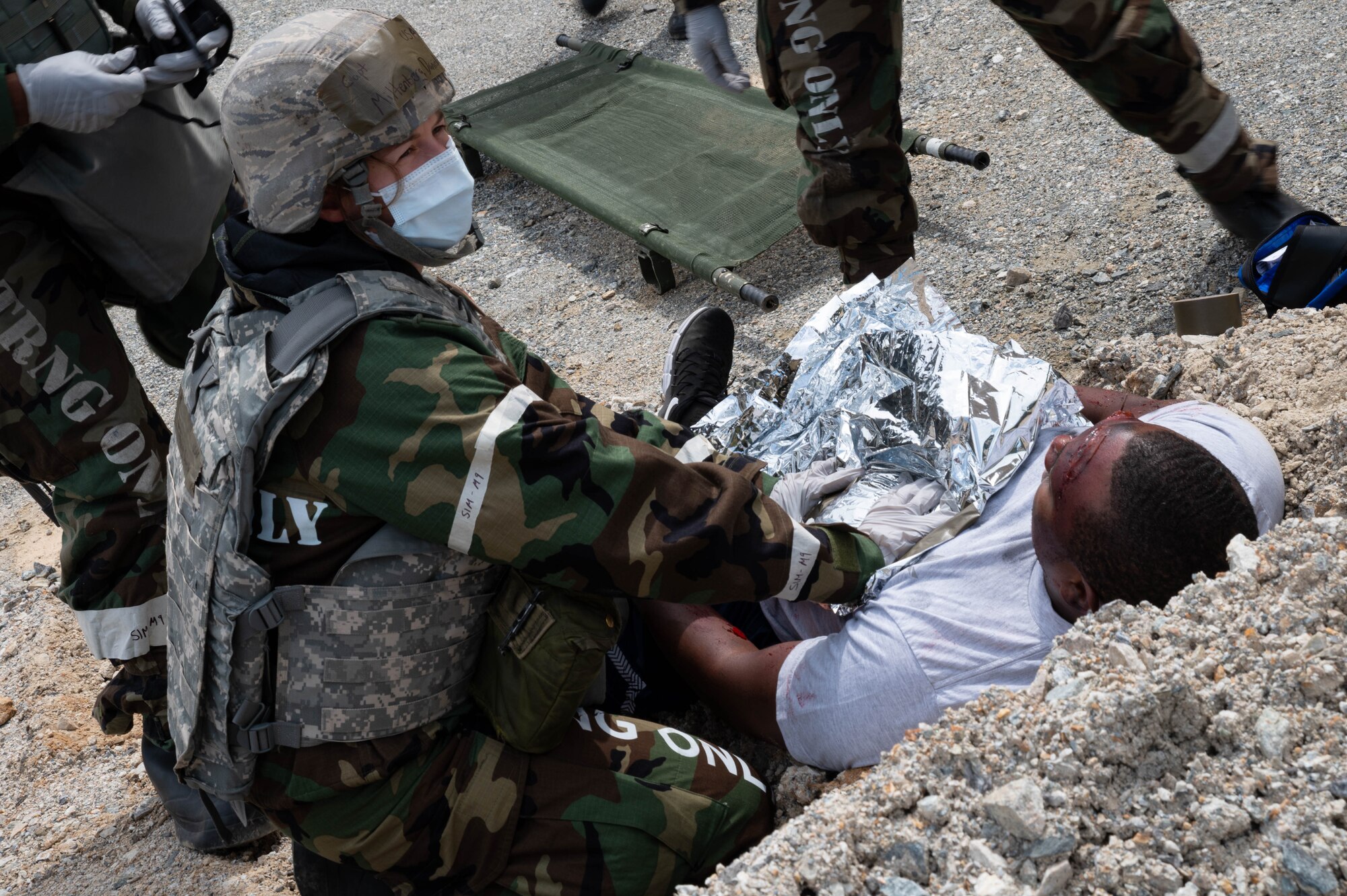 Capt. Danielle Miltenberg from the 51st Medical Group places a warming blanket on a patient during a mass casualty training event