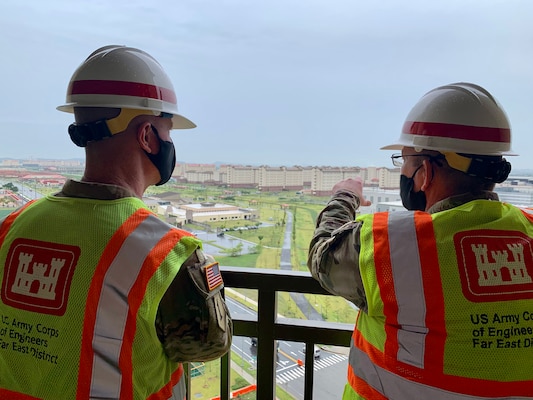 Brig. Gen. Kirk Gibbs (left), U.S. Army Corps of Engineers Pacific Ocean Division commander, listens to Col. Christopher Crary (right), Far East District commander, as they look from the balcony of the newly constructed Army Family Housing Towers at USAG Humphreys, Aug. 25.