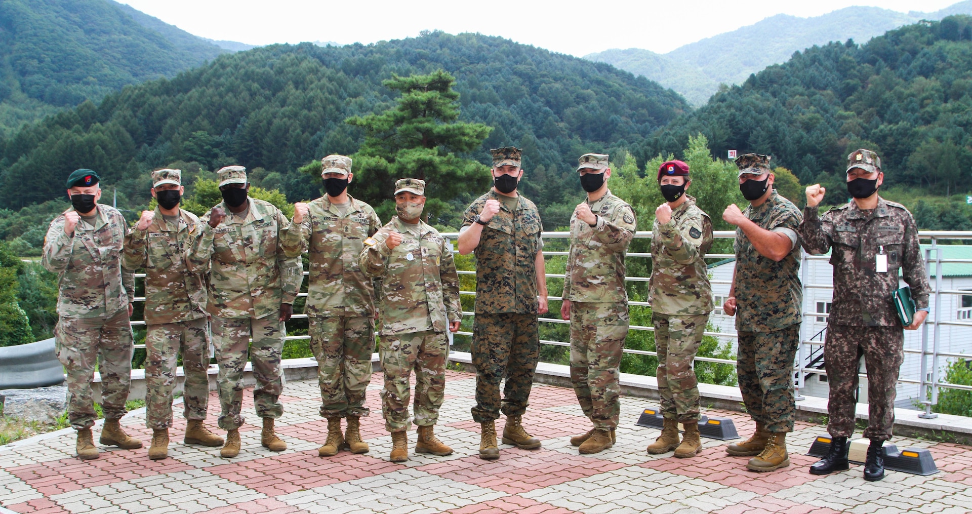 Group photo of US and Korea Army soldiers posing with their fists raised