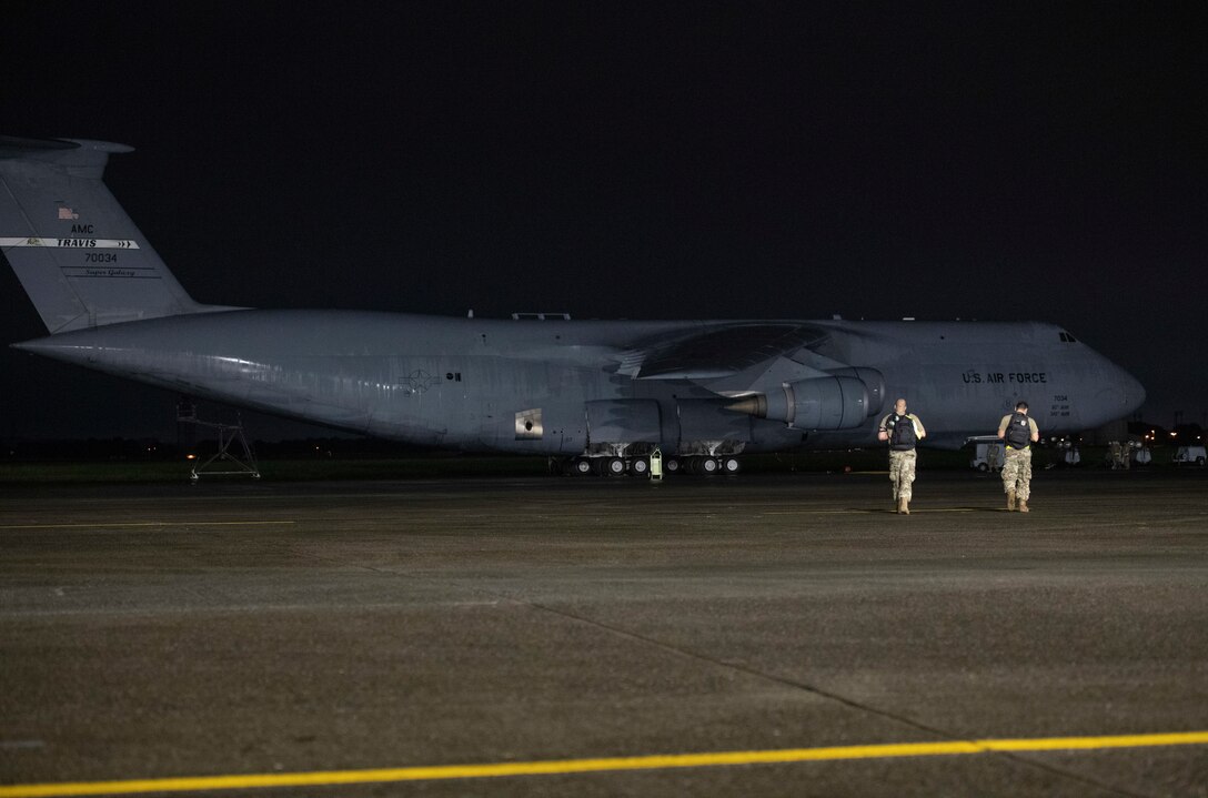 Tech. Sgt. Terence Young, 730th Air Mobility Squadron aircraft maintenance craftsman, left, and Senior Airman Peter Gutierrez, 730th AMS aircraft propulsion journeyman, walk to a C-5M Super Galaxy at Yokota Air Base, Japan, Sept. 15, 2021. Through a special request to Pacific Air Forces, the 730th AMS was able to utilize a C-5M for familiarization training. (U.S. Air Force photo by Staff Sgt. Joshua Edwards)