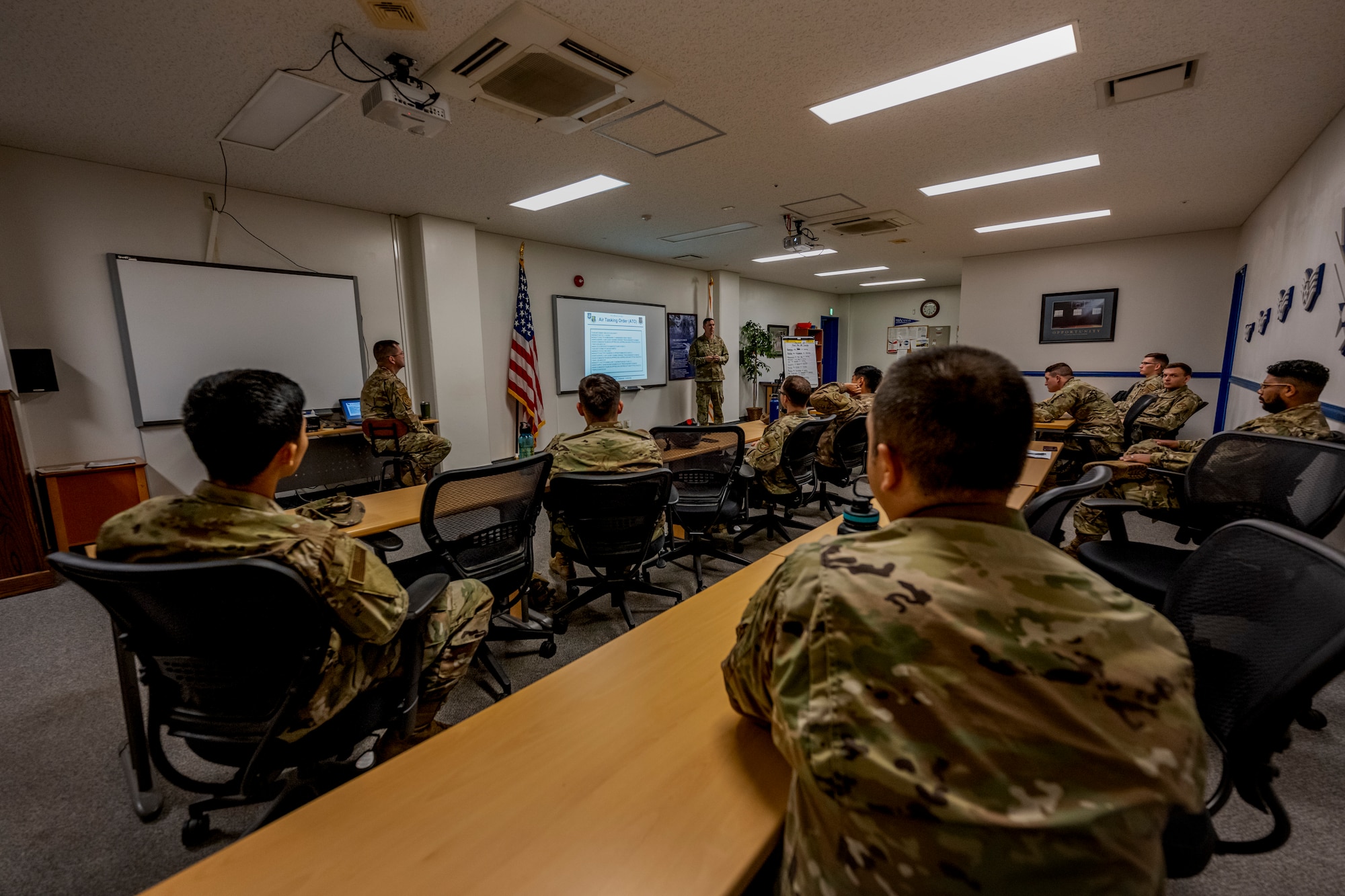 Several people in uniform sit in a classroom.