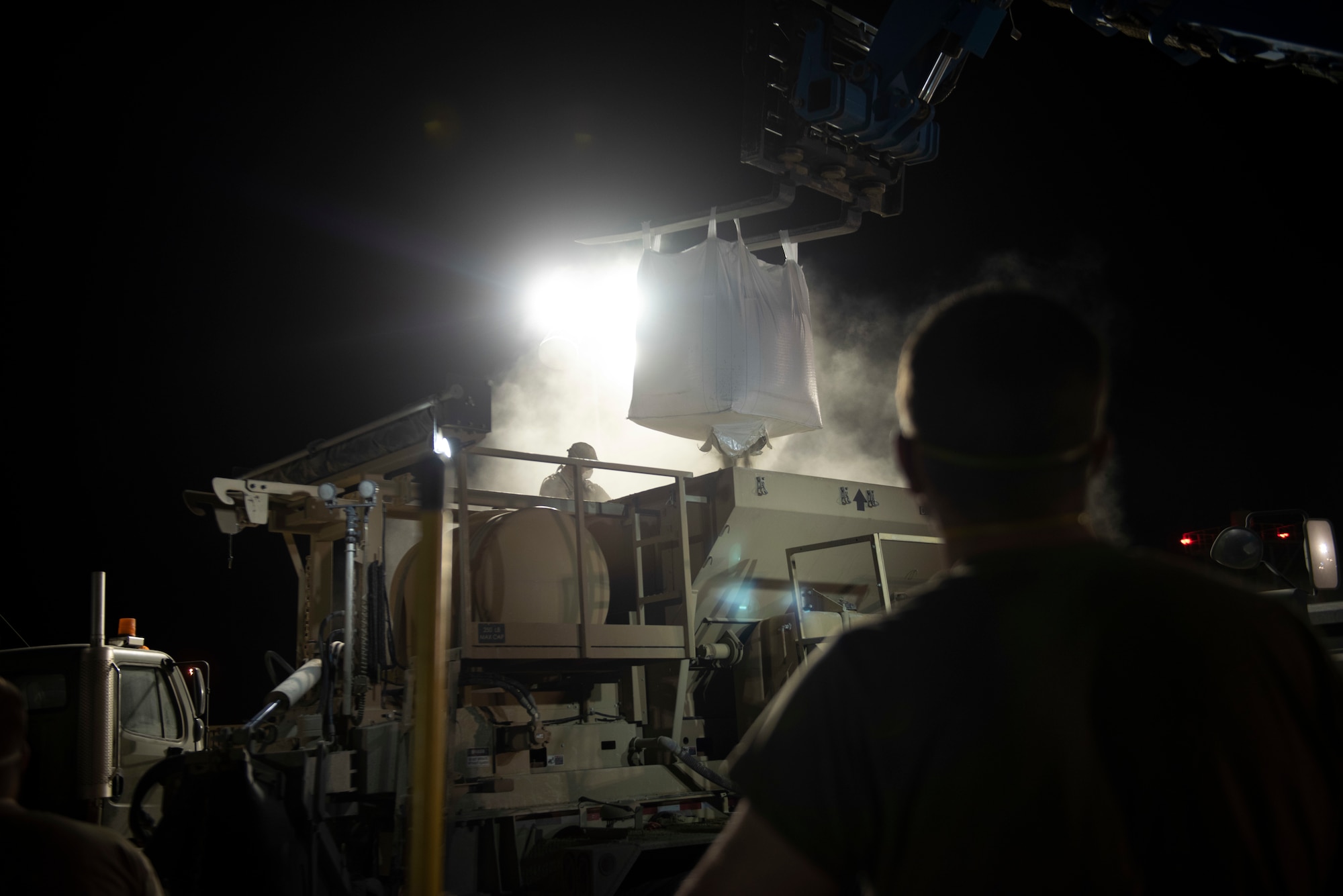 A photo of Airmen putting dry concrete into a mixer