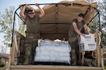 Oklahoma National Guard Spcs. Michael West, left, and Gage Stone, truck drivers with Alpha Company, 120th Engineer Battalion, 90th Troop Command, distribute water, ice and food to those affected by Hurricane Ida in LaPlace, Louisiana, Sept. 7, 2021. Oklahoma National Guardsmen drove throughout neighborhoods to distribute supplies directly to residents.