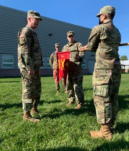 Brig. Gen. Andrew D. Preston, left, the commandant of the Field Artillery School and Army chief of artillery, joins Capt, Daniel Rogers, the commander of Alpha Battery, 1st Battalion, 258th Field Artillery  in affixing an award streamer to the company guidon during a ceremony honoring the unit  in New Windsor, New York, Sept. 11, 2001. The battery received the Hamilton Award, which recognizes the outstanding artillery battery in the Army National Guard.