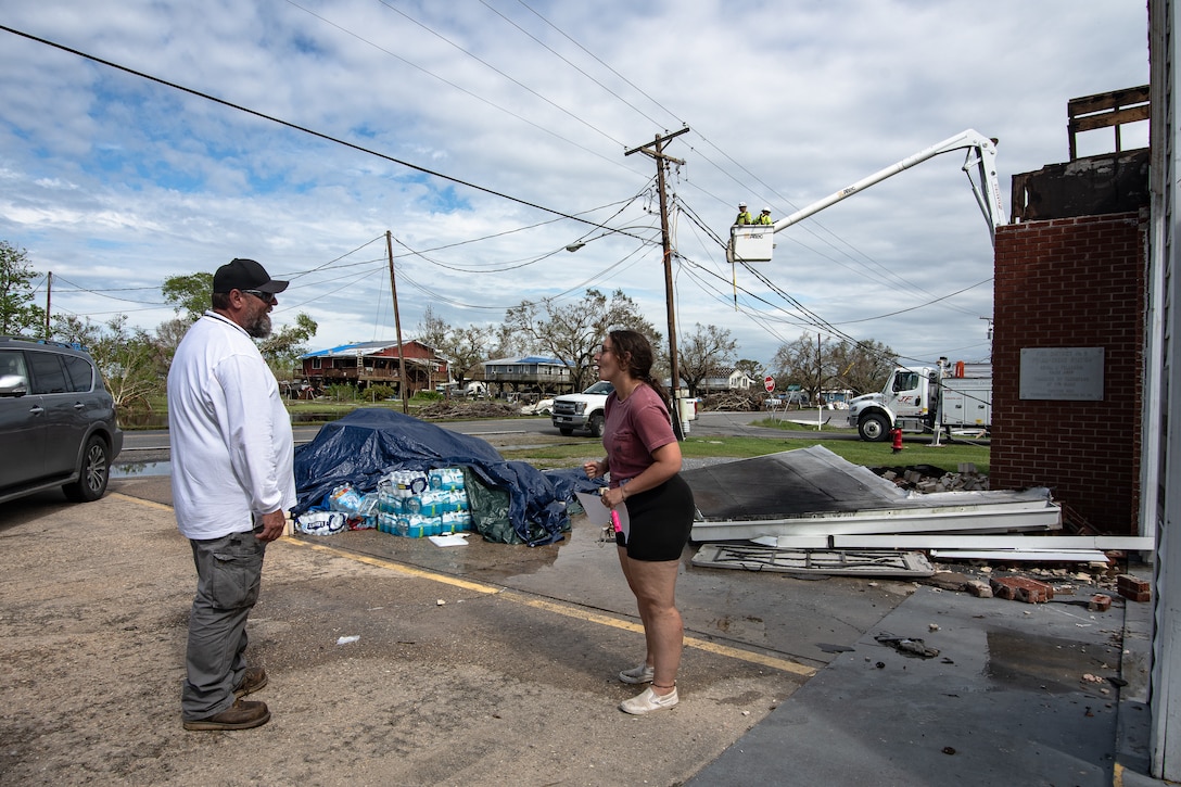 James Muilenburg, a US Army Corps of Engineers, Omaha District employee serving as a national local government liaison, talks with Lindsey Dupree, a nursing student that came home and took over a food bank and distribution site in Point Aux Chene Louisiana.