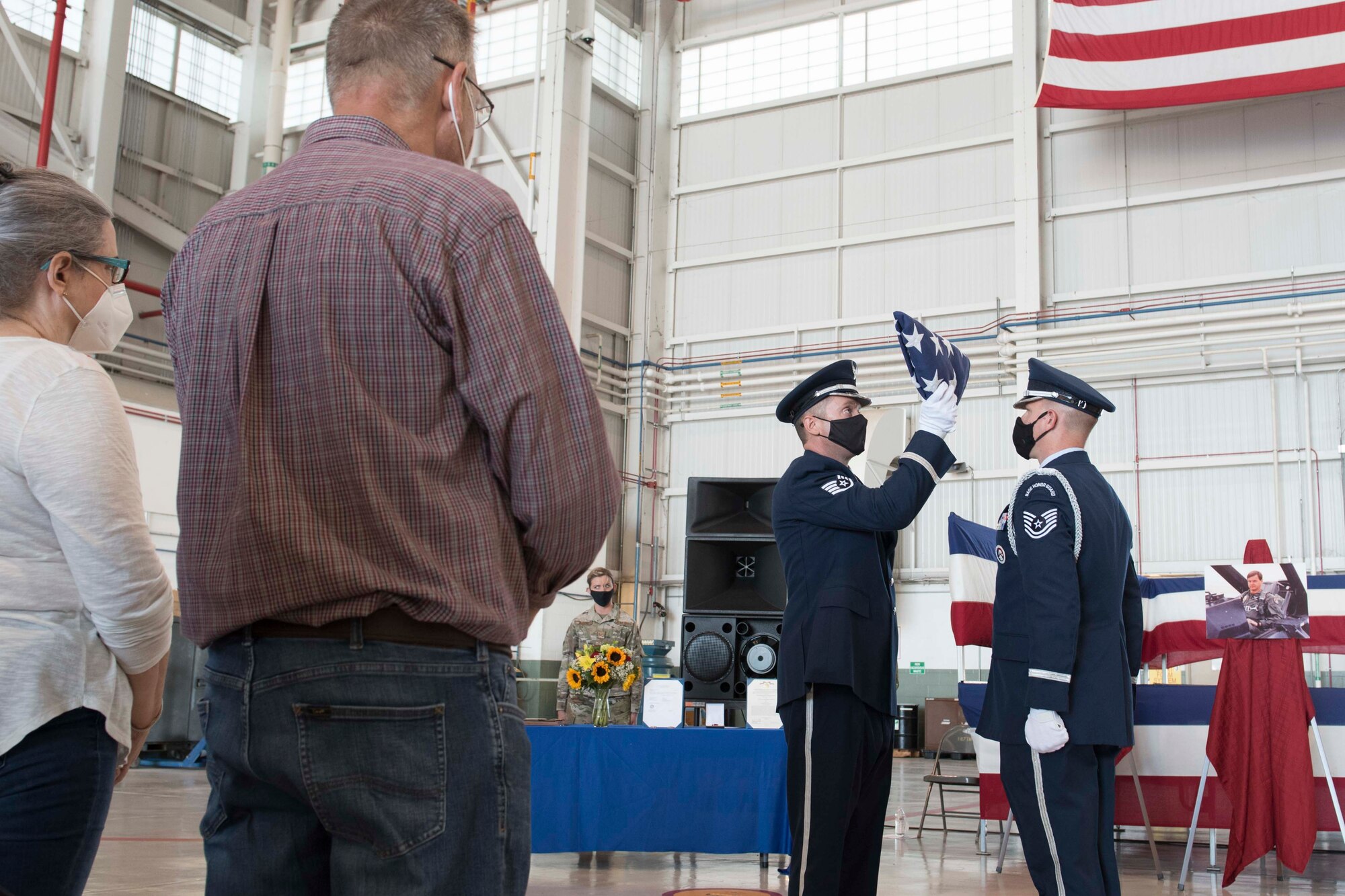 167th Airlift Wing Honor Guard members, Staff Sgt. Tim Sencindiver and Tech. Sgt. Jonathan Engler, conclude a flag folding during a memorial service for Lt. Col. Barry Rowekamp held in an aircraft hangar, Shepherd Field, Martinsburg, West Virginia, Aug. 19, 2021. (U.S. Air National Guard photo by Senior Master Sgt. Emily Beightol-Deyerle)