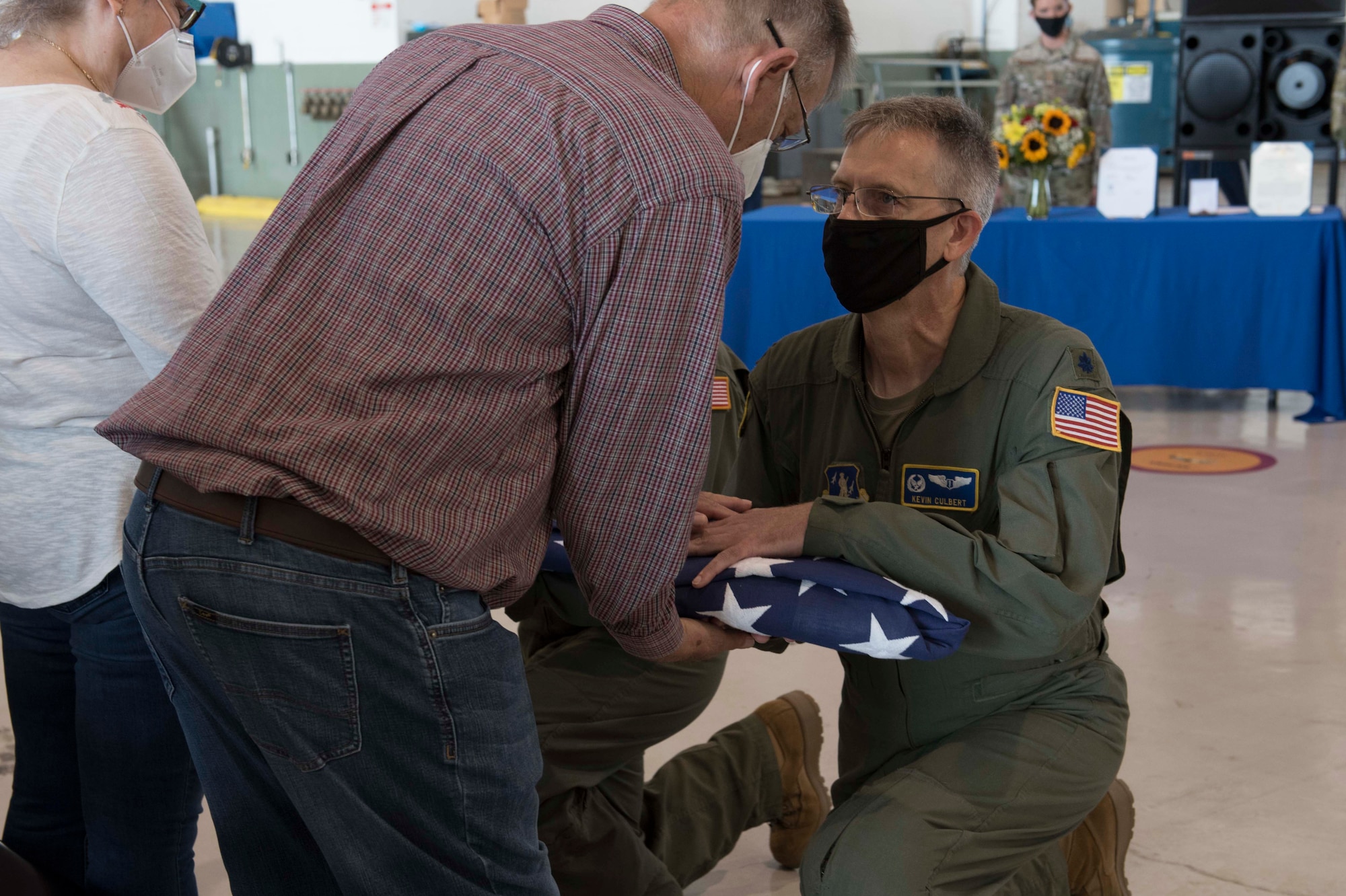U.S. Air Force Lt. Col. Kevin Culbert, 167th Medical Group commander, presents a flag to William Rowekamp, brother of Lt. Col. Barry Rowekamp, during a memorial service held in a maintenance hangar at the 167th Airlift Wing, Martinsburg, West Virginia, Aug. 19, 2021. Rowekamp was the wing’s chief of aerospace medicine. (U.S. Air National Guard photo by Senior Master Sgt. Emily Beightol-Deyerle)