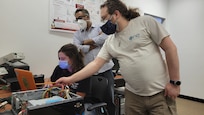 IMAGE: (From left to right) Cathlyn Stone, Binoy Ravindran and Joshua Bockenek review software solution in development. Led by Professor Ravindran, Stone and Bockenek are doctoral students participating in a three-year NEEC project in partnership with NSWCDD.
