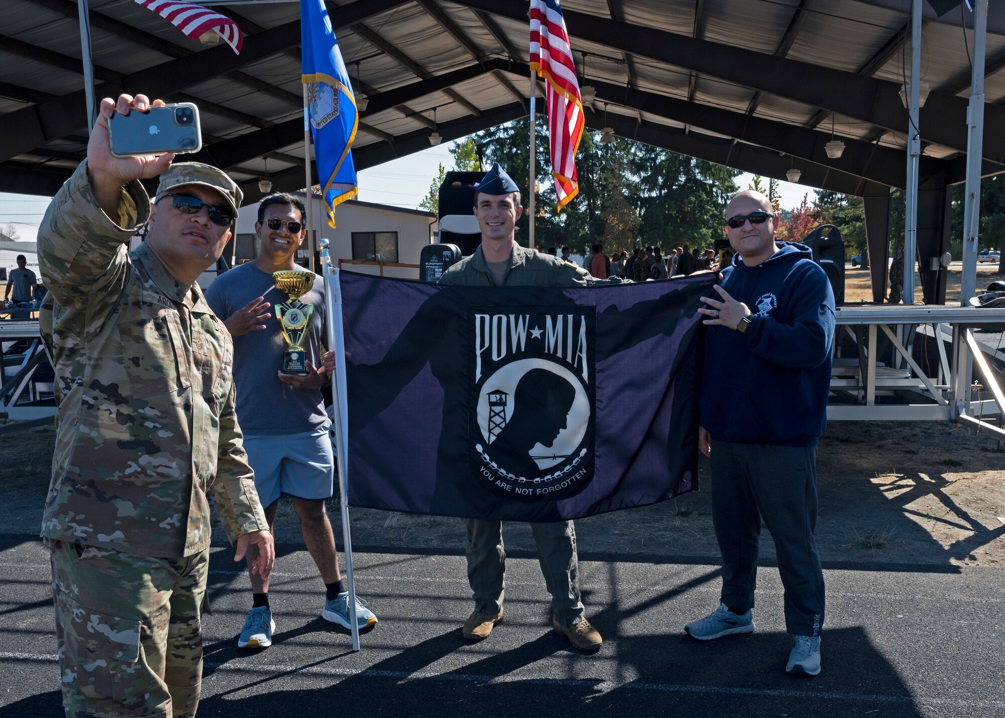 U.S. Air Force Chief Master Sgt. Joseph Arce, 62nd Airlift Wing command chief, takes a photo with 4th Airlift Squadron Airmen after receiving the award for most miles ran by a team during the 24-hour POW/MIA Remembrance Run at Joint Base Lewis-McChord, Washington, Sept. 16, 2021. Airmen with the 4th AS ran 234 miles in total; paying their respects to the memory of those Americans who were prisoners of war or were, and may still be, missing in action. (U.S. Air Force photo by Senior Airman Zoe Thacker)