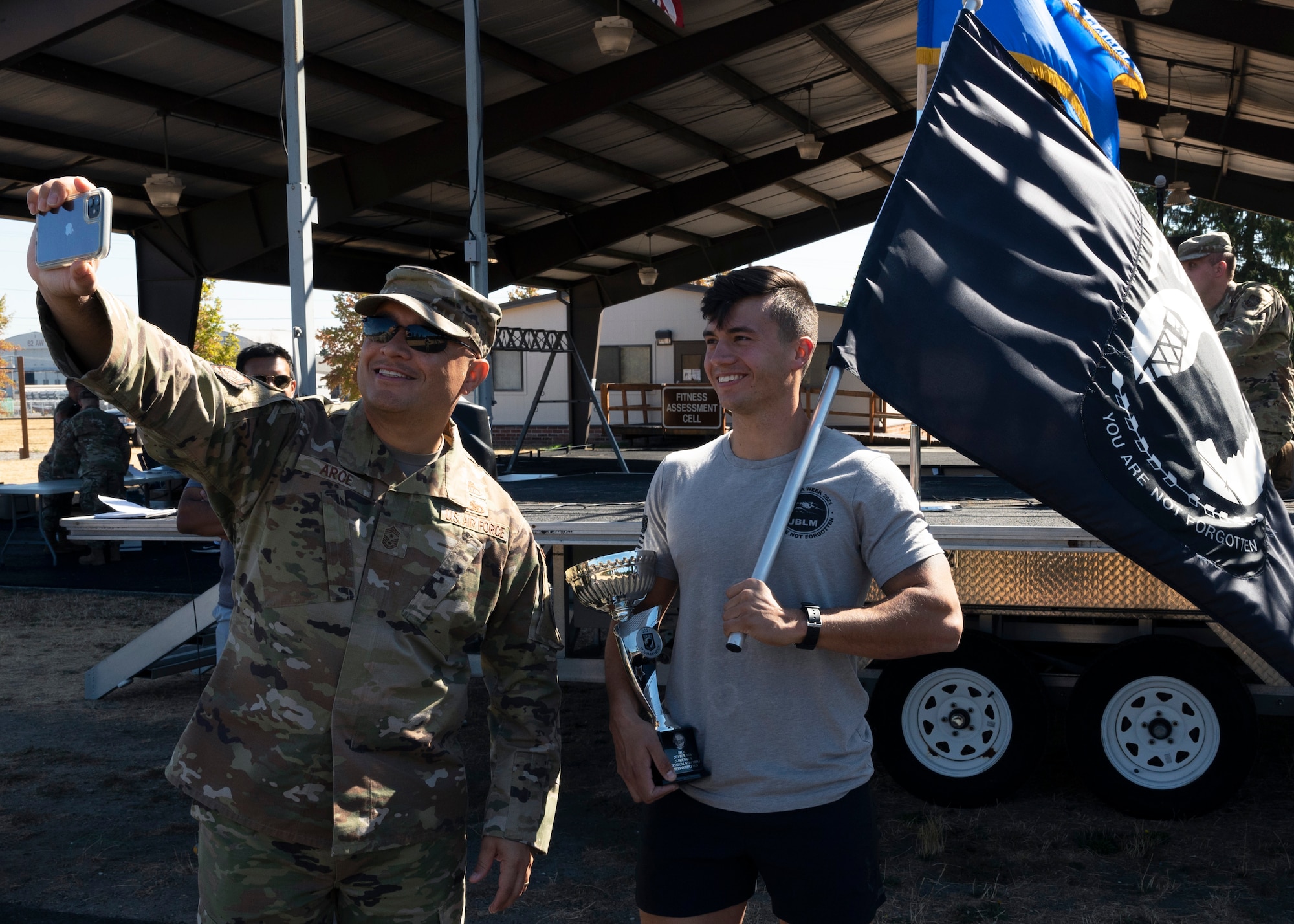 U.S. Air Force Chief Master Sgt. Joseph Arce, 62nd Airlift Wing command chief, takes a photo with Senior Airman Patrick Christofferson, an aerospace ground equipment Airman with the 62nd Maintenance Squadron, after receiving the award for most miles ran by a single individual during the 24-hour POW/MIA Remembrance Run at Joint Base Lewis-McChord, Washington, Sept. 16, 2021. Christofferson ran 26.6 miles in total; paying his respects to the memory of those Americans who were prisoners of war or were, and may still be, missing in action. (U.S. Air Force photo by Senior Airman Zoe Thacker)