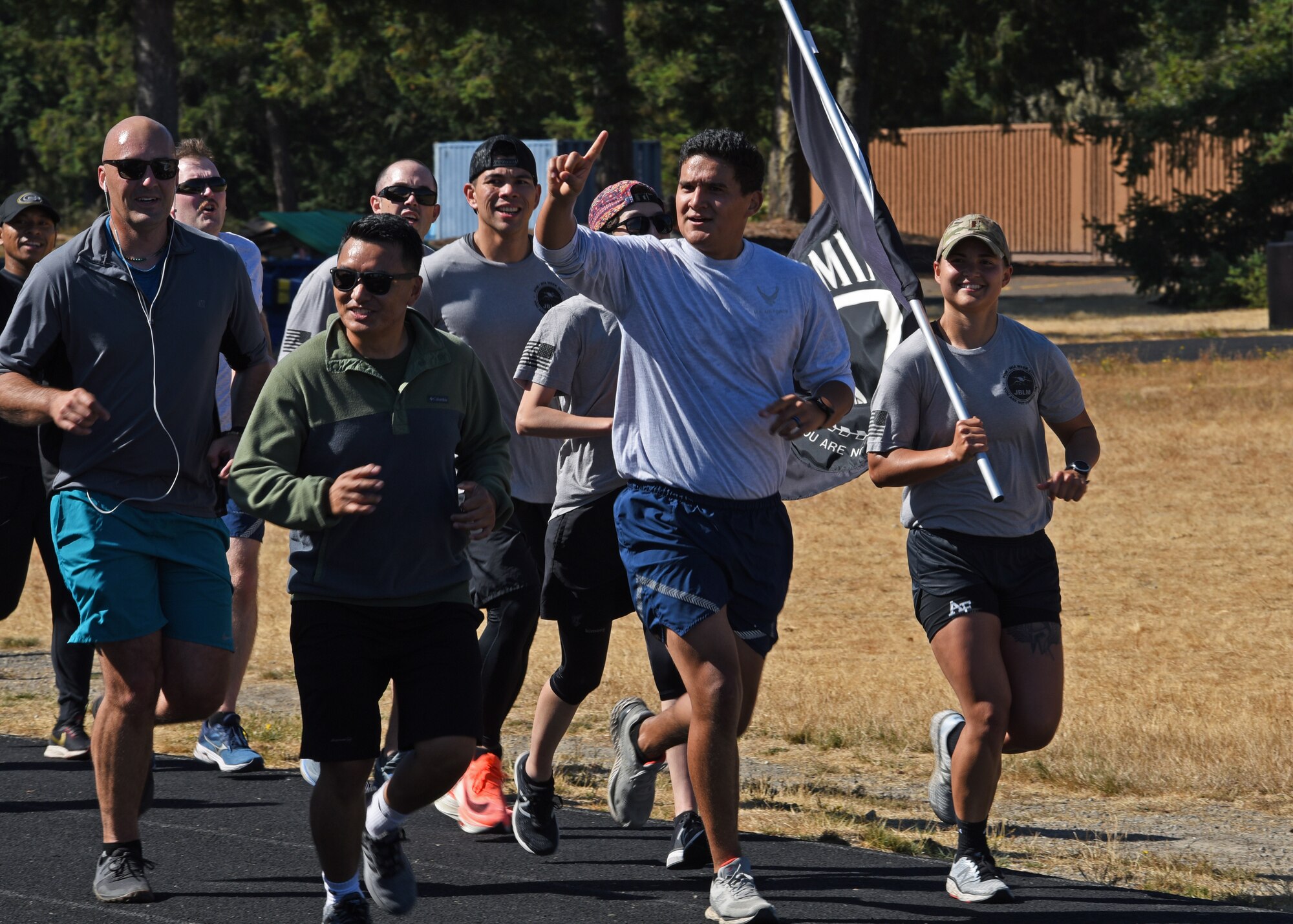 U.S. Airmen with the 627th Civil Engineer Squadron run their final lap with the POW/MIA flag during the 24-hour remembrance run at Joint Base Lewis-McChord, Washington, Sept. 16, 2021. Collectively, Team McChord ran more than 300 miles to honor the sacrifice and memory of those Americans who were prisoners of war or were, and may still be, missing in action. (U.S. Air Force photo by Senior Airman Zoe Thacker)