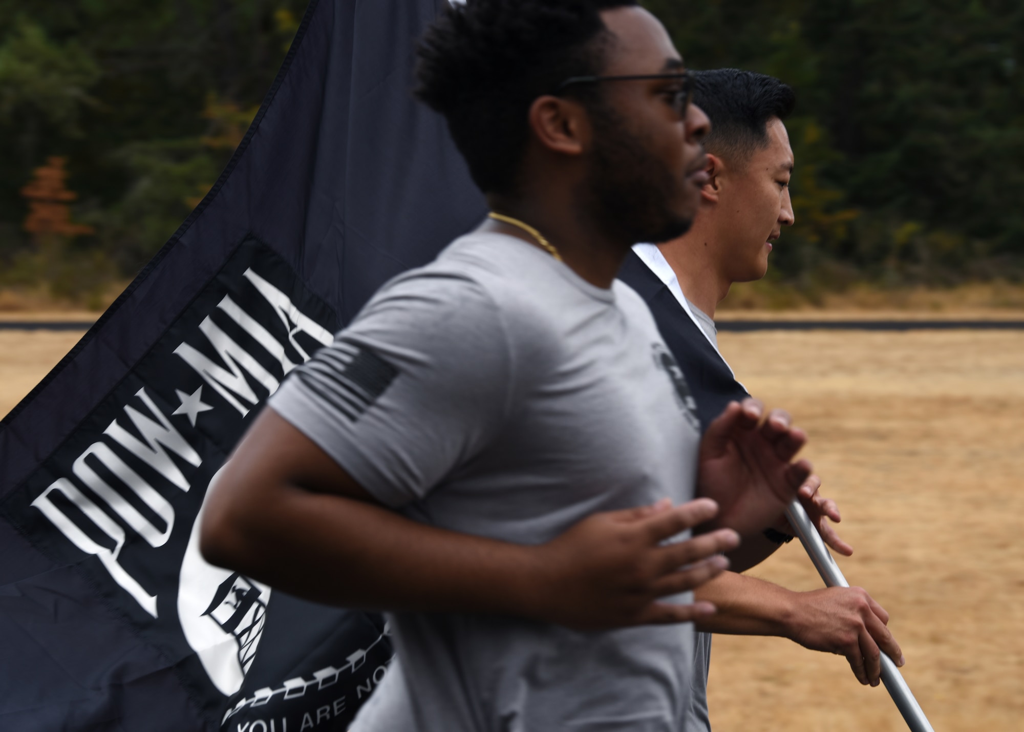 U.S. Airmen with the 62nd Comptroller Squadron carry the POW/MIA flag on the McChord Field track while participating in the 24-hour POW/MIA Remembrance Run at Joint Base Lewis-McChord, Washington, Sept. 15, 2021. Team McChord planned several events this week to honor the lives and sacrifices of those men and women who were prisoners of war or missing in action, including a Missing Man Table and Honors Ceremony, a community motorcycle ride and a wreath laying ceremony. (U.S. Air Force photo by Senior Airman Zoe Thacker)